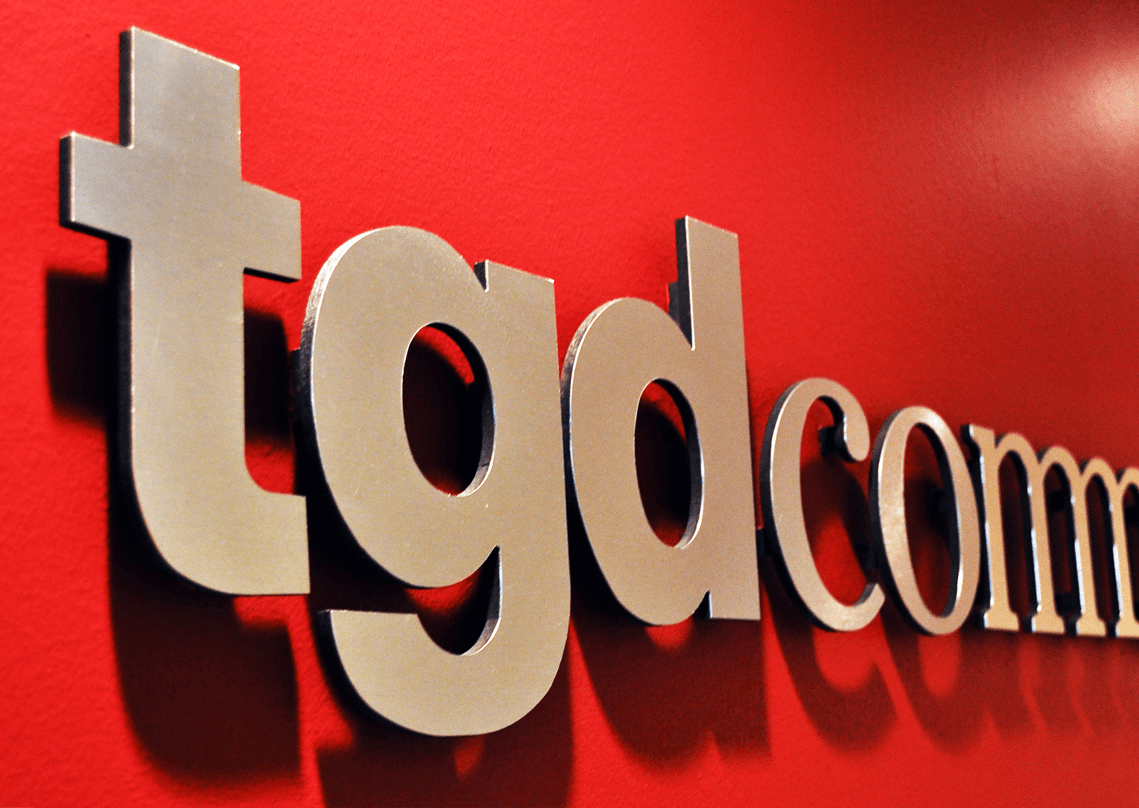 Picture of 2 women talking at a table in front of a sign reading "Welcome to the Opinion Donor Lounge"